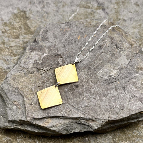 Two high-shine plain brass diamonds stacked pendant on a 16