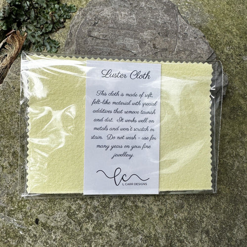 Packaged Luster Cloth with a label on a stone surface