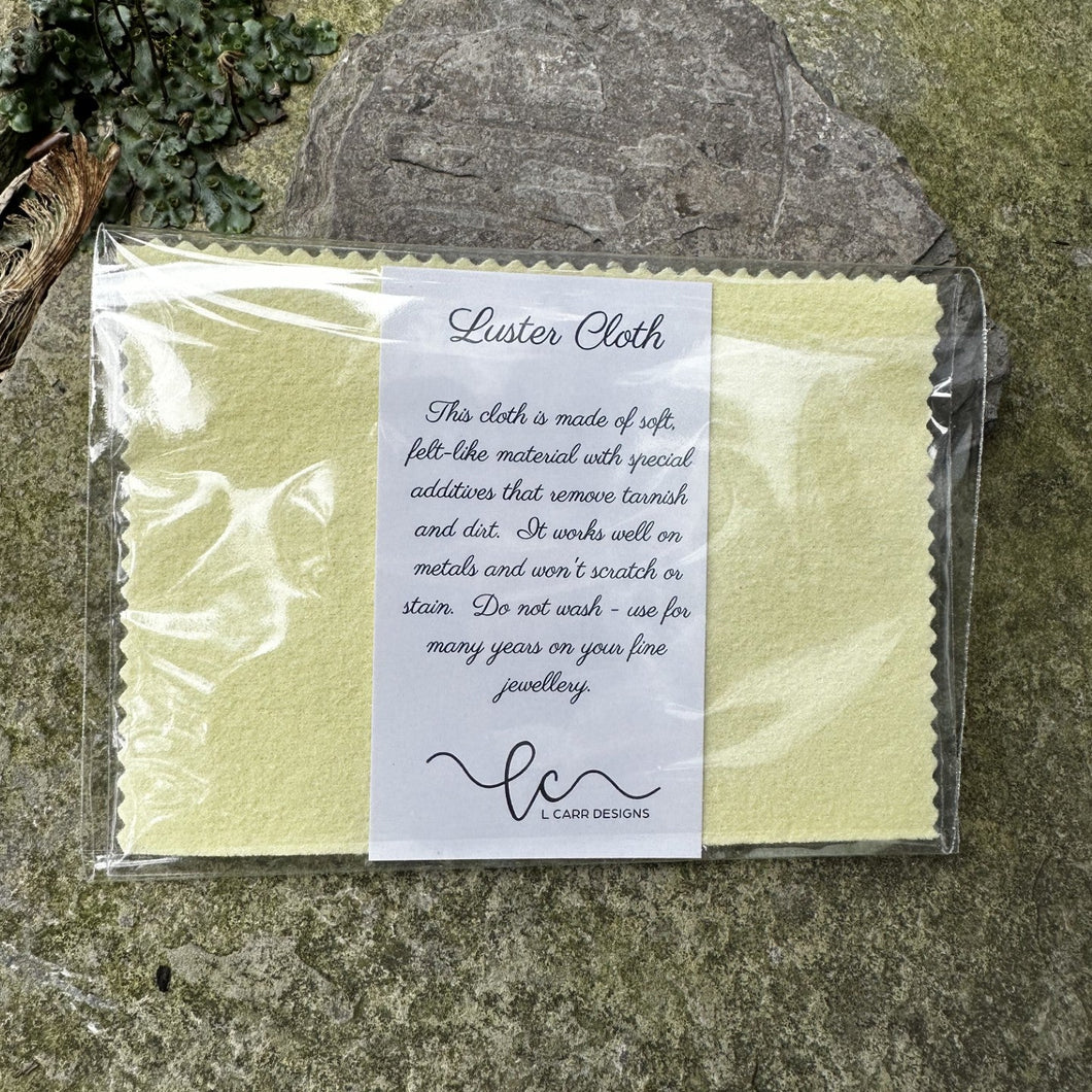 Packaged Luster Cloth with a label on a stone surface